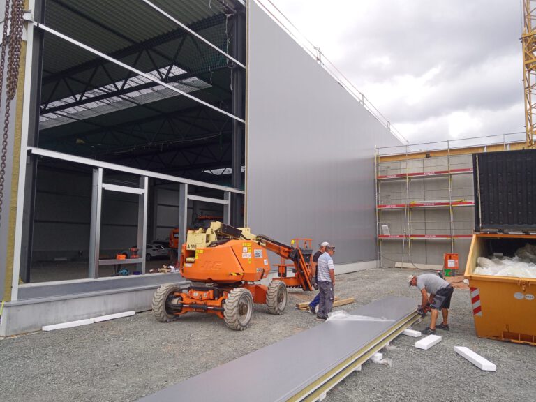 Bauvorhaben Stahlgruber Kaiserslautern: Vorbereitung einer anthrazit Sandwichpaneel zur Fassadenmontage