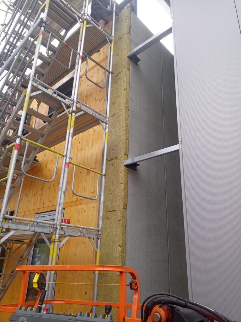 Bauvorhaben Stahlgruber Kaiserslautern: Montage der Wärmedämmung mit Mineralwolle an der Fassade einer Industriehalle