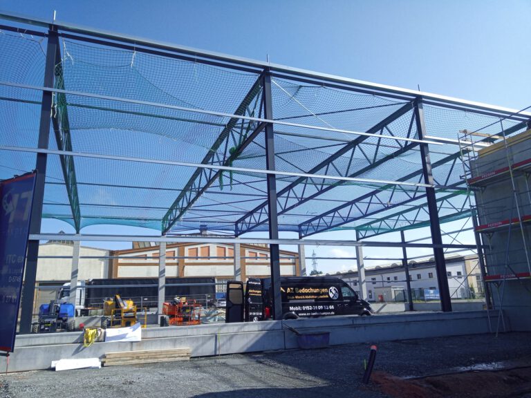 Bauvorhaben Stahlgruber Kaiserslautern: Stahlkonstruktion einer Industriehalle mit Auffangnetz und Firmenwagen im Saarland