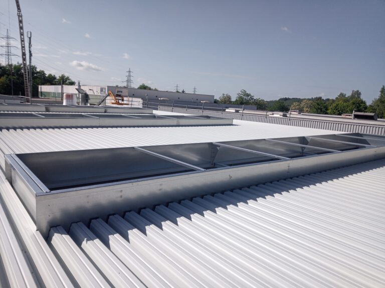 Eingedecktes Dach einer Industriehalle mit weißem Trapezblech und integrierten Lichtbändern im Saarland